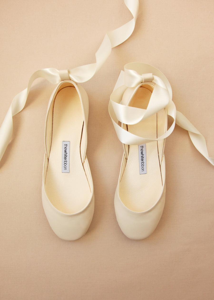 pair of vanilla ivory coloured smooth leather ballerinas with satin bands from top view