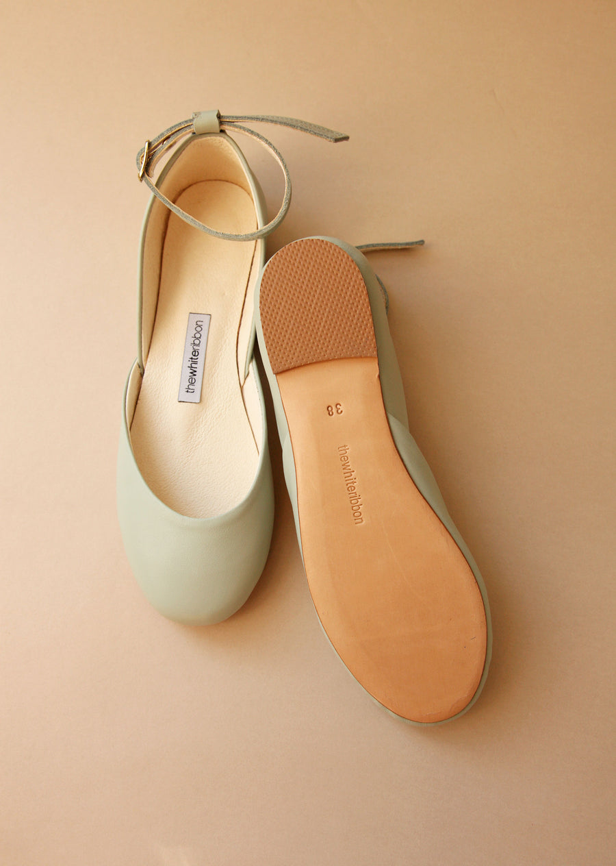 sole and top shown of pair of light mint ballet flats with ankle straps