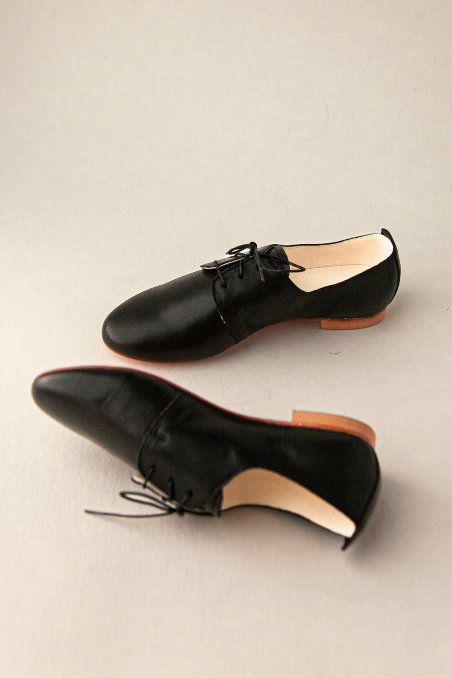 Pair of black shoes on a beige background