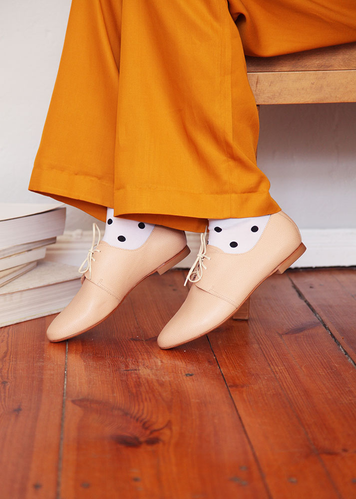 side shot of nude leather derby shoes on model 