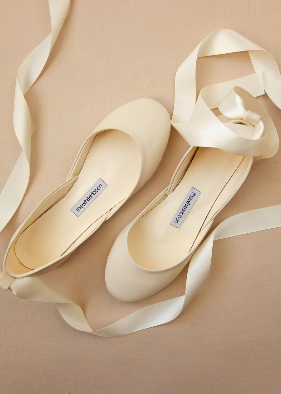 top shot of leather ballet flats in vanilla ivory shade with satin straps