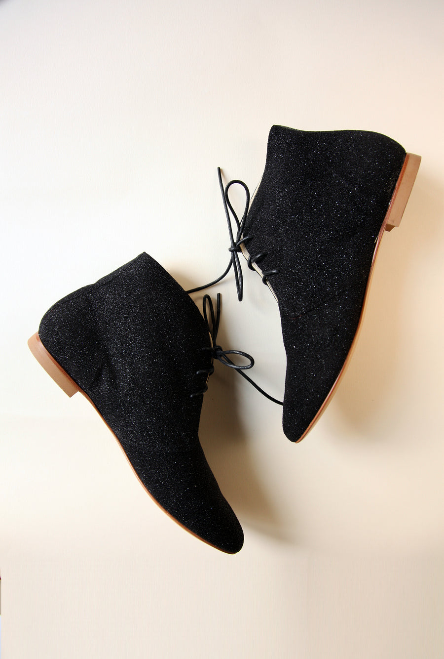 black sparkling ankle boots shown from the sides with white blackground