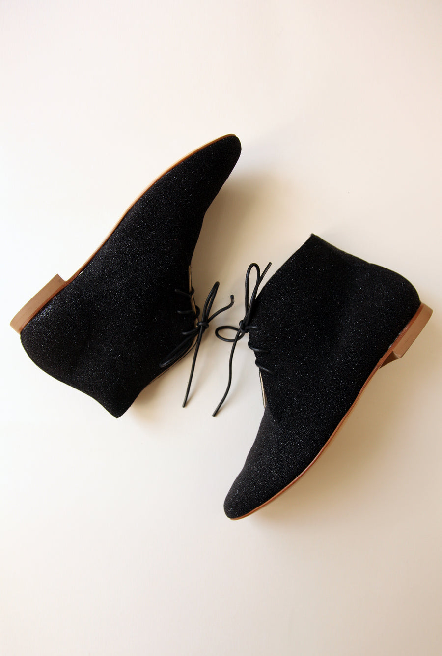 a pair of sparkling black ankle boots shown from the side
