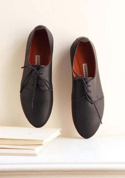 top view of a pair of black smooth leather saddle shoes 