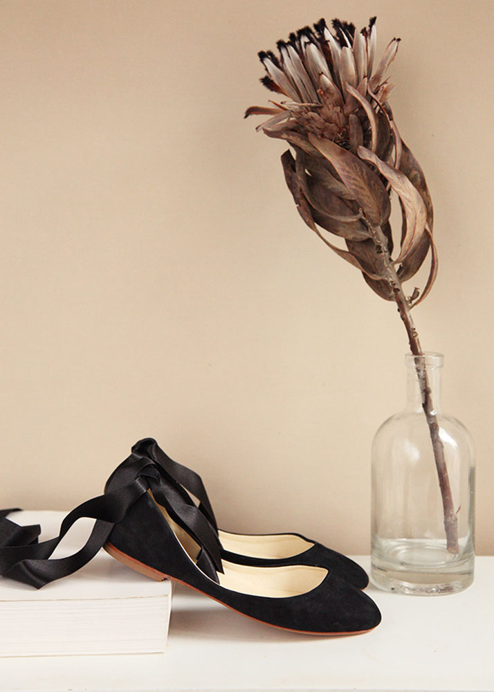 side view of black nubuck ballet flats with black satin ribbons