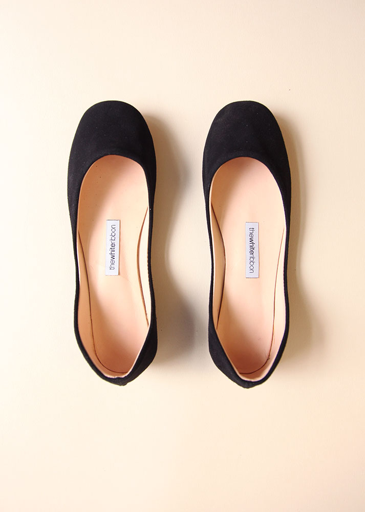 a pair of black ballet flats in top view with white background