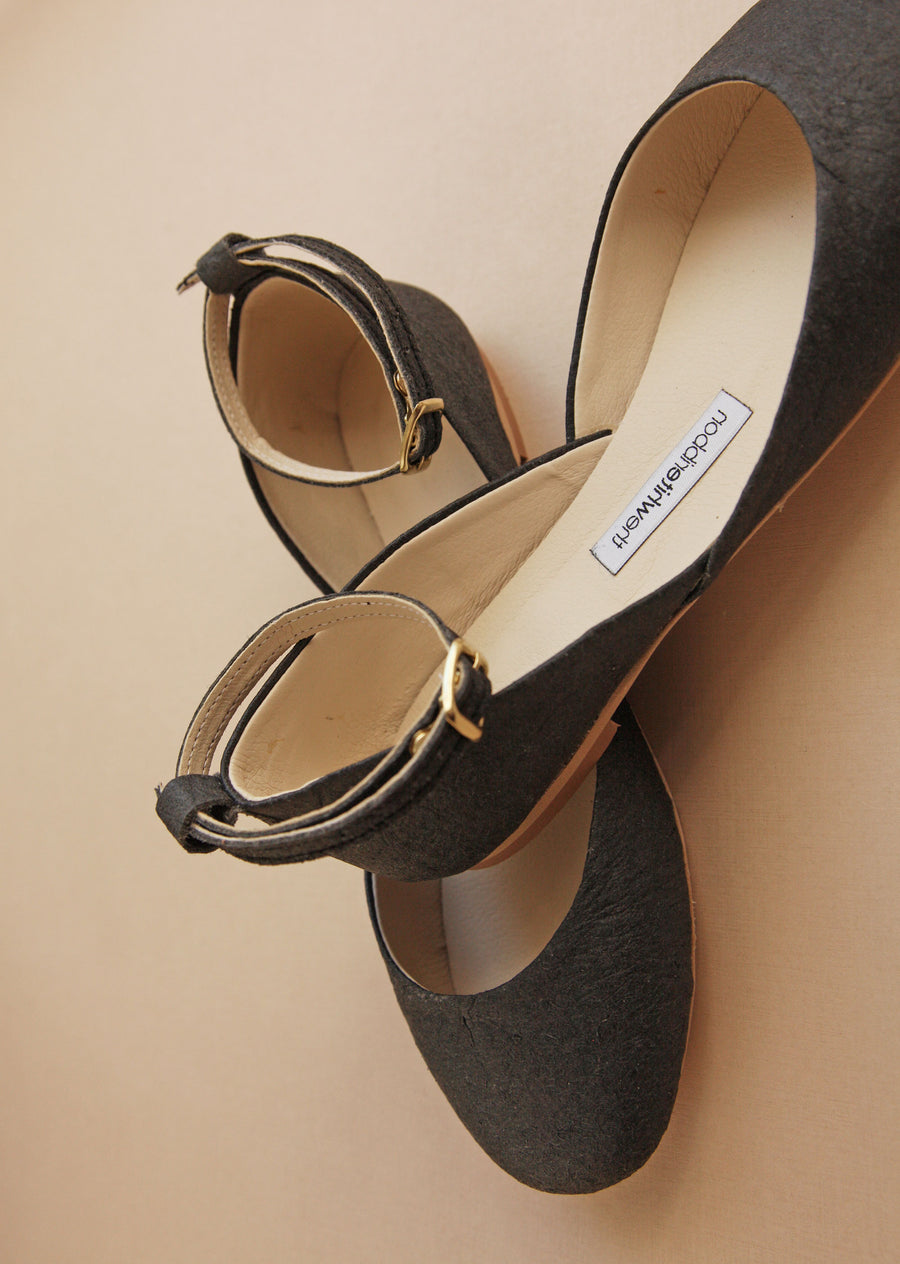 close-up of heel and front of black vegan ballet flats with matching straps  